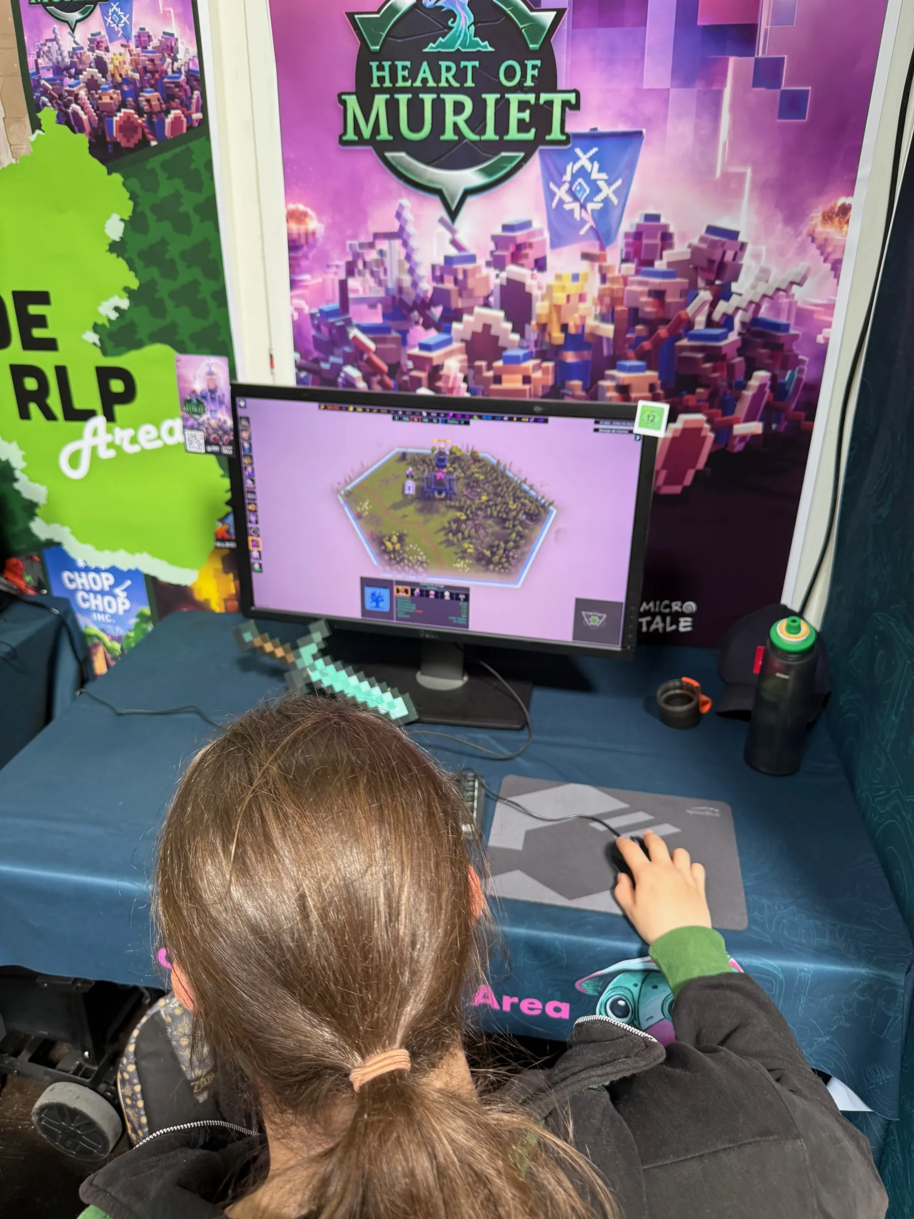 A young player trying the Heart of Muriet demo at the DoKomi booth